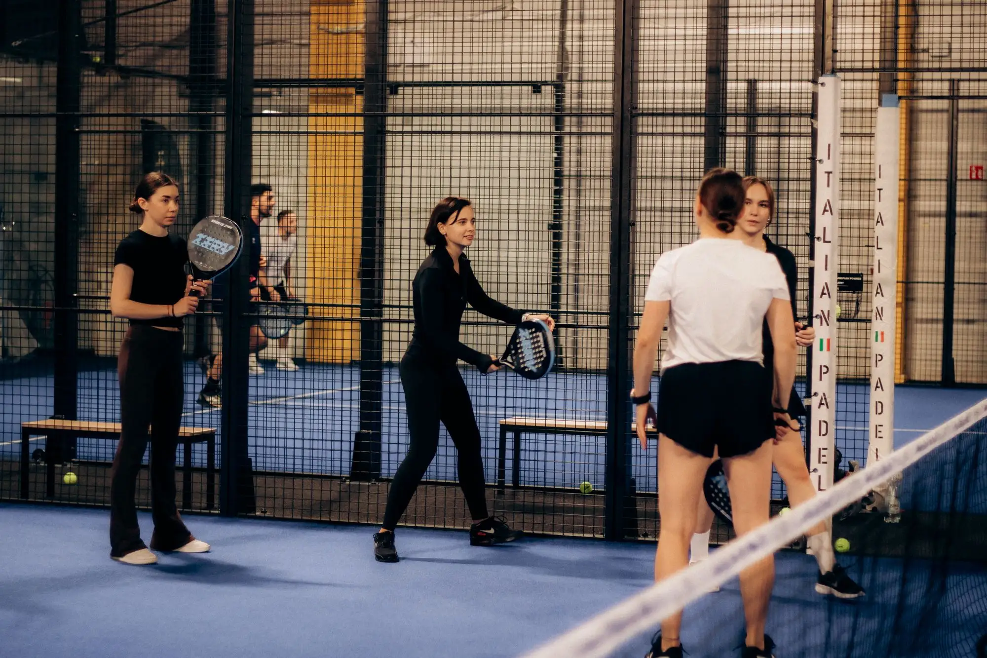 Des joueuses et joueurs sur des terrains de padel couverts
